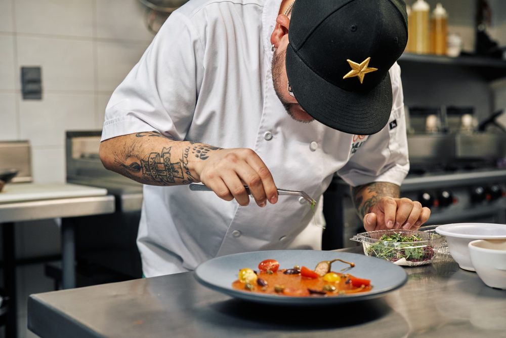 Chef emplatando un plato en la cocina de un restaurante